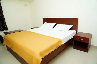 a bedroom with a large bed with a wooden headboard at Meadow Comfort Stay in Coimbatore