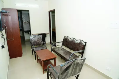 a room with chairs and a table and a bench at Meadow Comfort Stay in Coimbatore