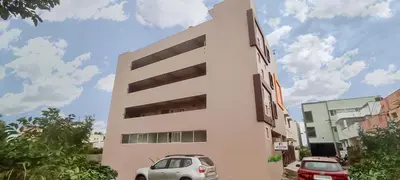 a white building with cars parked in front of it at Meadow Comfort Stay in Coimbatore