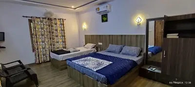 a bedroom with two beds and a chair at Spice Garden Farm house in Sultan Bathery