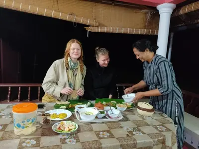 a group of people standing around a table with food at Spice Garden Farm house in Sultan Bathery