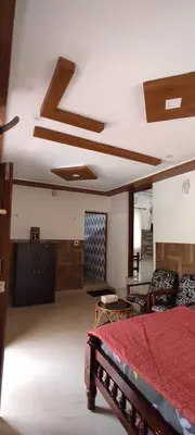 a bedroom with a bed with a red comforter at Spice Garden Farm house in Sultan Bathery