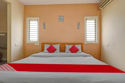 a bedroom with a large bed with red pillows at Super Hotel O Indra Suites in Mysore