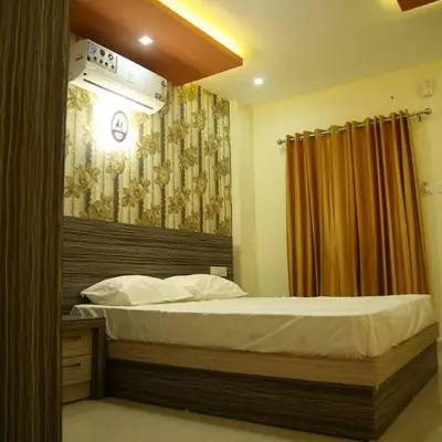 a bedroom with a large bed with a curtain at City Tower Lodge in Nilambūr