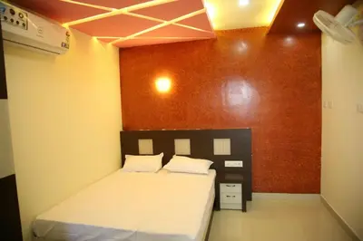 a bedroom with a bed and a red wall at City Tower Lodge in Nilambūr