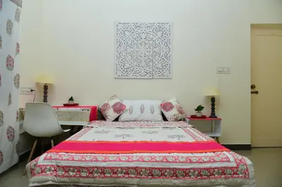 a bedroom with a bed and a table and a chair at RAATREE in Mysore