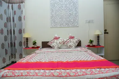 a bedroom with a large bed with a red and white blanket at RAATREE in Mysore