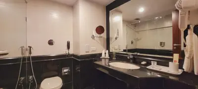 a bathroom with two sinks and a large mirror at ASHOKA INN in Trichūr
