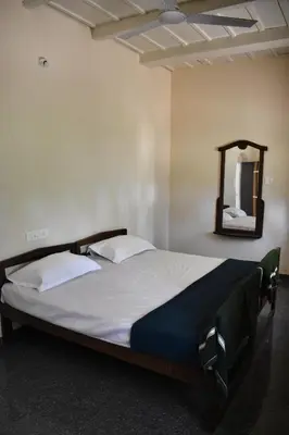 a large bed in a room with a mirror at Rochas Valley Homestay in Suntikoppa