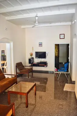 a living room with a couch and a tv at Rochas Valley Homestay in Suntikoppa
