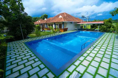 a swimming pool in front of a house at KOTTACKAL NATURE INN in Nedumbassery