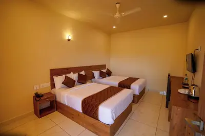 a hotel room with two beds and a television at KOTTACKAL NATURE INN in Nedumbassery