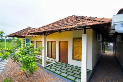 a small house with a pathway leading to the front door at KOTTACKAL NATURE INN in Nedumbassery