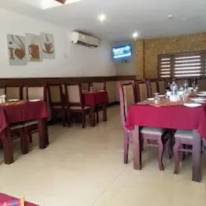 a dining room with tables and chairs with purple table cloth at Kottaram Hotels Ottaplam in Palakkad