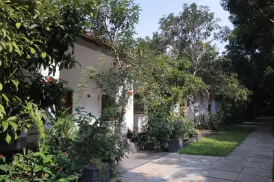 a white house with trees and a sidewalk at Softouch Ayurveda Village Kerala in Kizhake Chālakudi