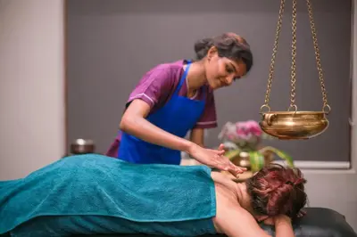 a woman getting a massage from a therapist at Softouch Ayurveda Village Kerala in Kizhake Chālakudi
