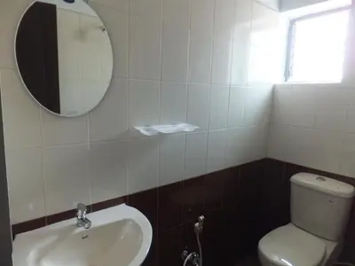 a bathroom with a white toilet and a mirror at KV Residency in Coimbatore