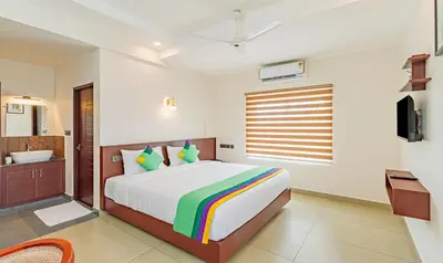 a bedroom with a bed and a tub and a sink at Treebo Amigos Residency in Cochin
