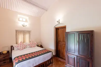 a bedroom with a bed and a wooden cabinet at Ibex Resorts, Coonoor Leewood in Coonoor