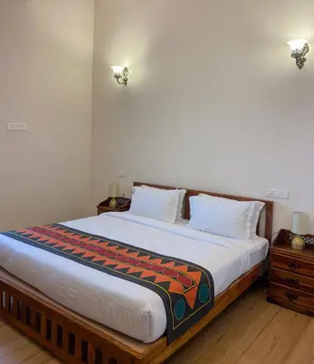 a bedroom with a large bed with a wooden frame at Ibex Resorts, Coonoor Leewood in Coonoor