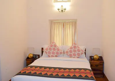 a bedroom with a bed with two pillows on it at Ibex Resorts, Coonoor Leewood in Coonoor