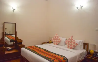 a bedroom with a large bed and a mirror at Ibex Resorts, Coonoor Leewood in Coonoor