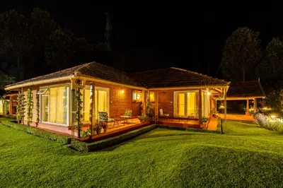 a house with a large lawn in front of it at amã Stays & Trails Raven's Nest , Kotagiri in Kotagiri