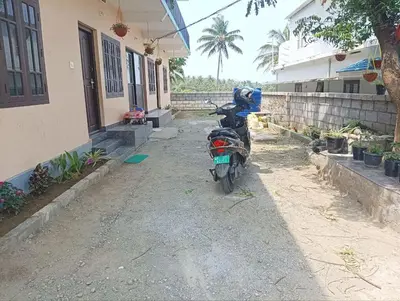 a motorcycle parked next to a house at BHASURI SERVICED VILLA in Varagampadi