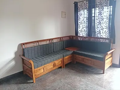 a wooden bench sitting in a room at BHASURI SERVICED VILLA in Varagampadi