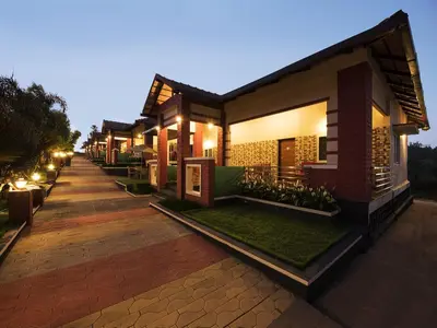 a row of houses at night with lights at Woodstock Resorts in Madikeri