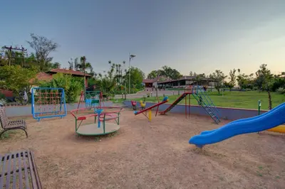 a park with a playground with slides and swings at Woodstock Resorts in Madikeri