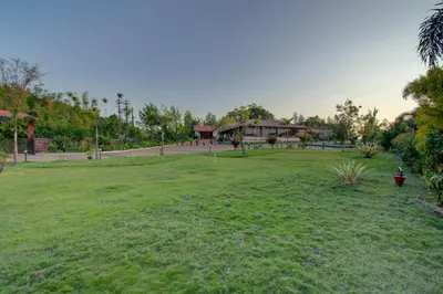 a park with a grass field and a pavilion at Woodstock Resorts in Madikeri