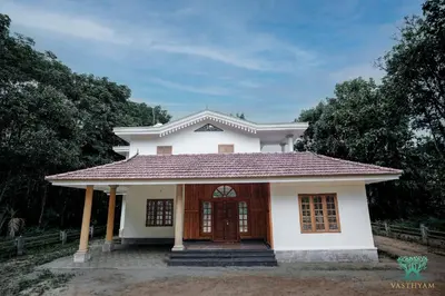 a small white house with a red roof at Vasthyam in Kenichira