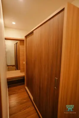 a large wooden door in a hallway with a mirror at Vasthyam in Kenichira
