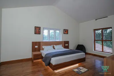 a bedroom with a bed and two windows at Vasthyam in Kenichira