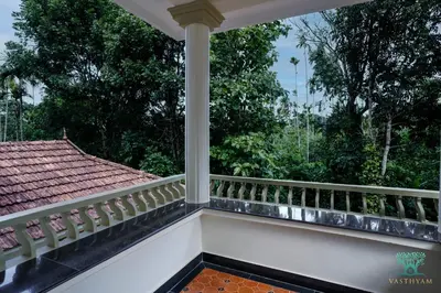 a balcony of a house with trees in the background at Vasthyam in Kenichira