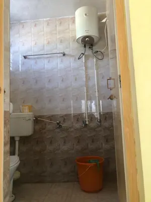 a bathroom with a toilet and a light on the wall at A Sweet home Homestay Second Floor in Palani