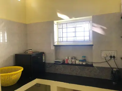 a kitchen with a window and a black refrigerator at A Sweet home Homestay Second Floor in Palani