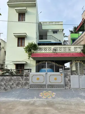 a white building with a gate in front of it at A Sweet home Homestay Second Floor in Palani