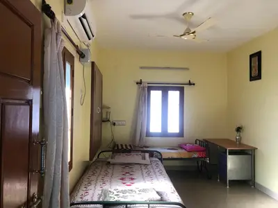 a bedroom with two beds and a window at A Sweet home Homestay Second Floor in Palani