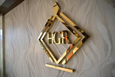 a wooden hrh sign hanging on a wall at Hotel Golden Riviera in Mysore