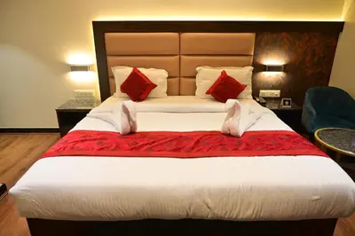a hotel room with a large bed with red pillows at Hotel Golden Riviera in Mysore