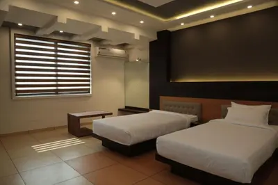a hotel room with two beds and a window at HOTEL AL AMANA TOWER in Kondotti