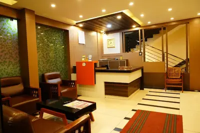 a lobby of a hotel with a kitchen and a living room at Rainbow Inn in Munnar