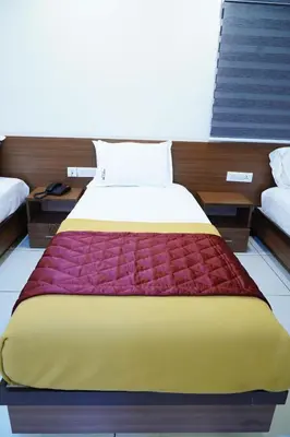 a bedroom with a large bed with a colorful blanket at Rainbow Inn in Munnar