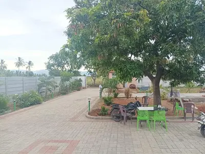 a park with tables and chairs and a tree at ANTARA STAY in Coimbatore