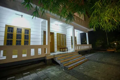 a building with stairs and a porch with yellow doors at B'camp Resorts & Homestays in Wayanad