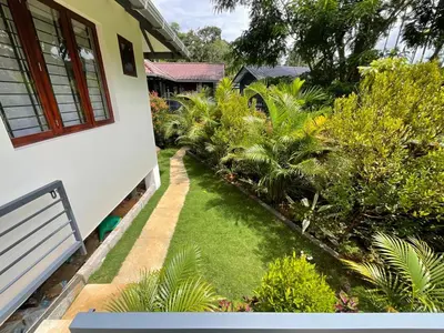 a garden with a bench next to a house at B'camp Resorts & Homestays in Wayanad