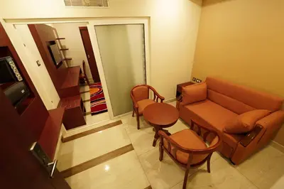 a living room with a couch and a table at Hotel Newline Orchid in Guruvāyūr