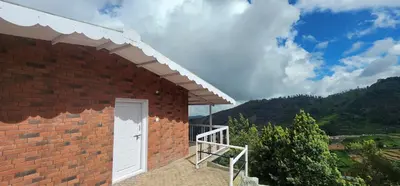 a brick building with a white door and a balcony at Heath Cote in Ooty